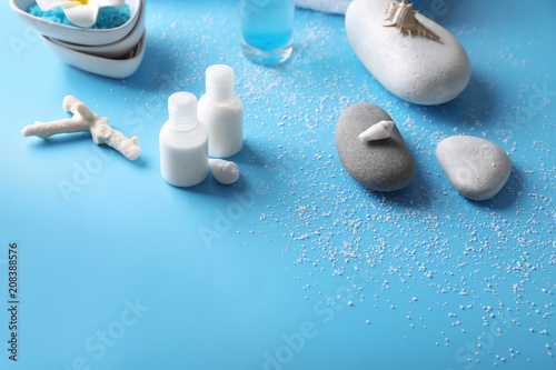 Beautiful spa composition with cosmetic products and stones on color background