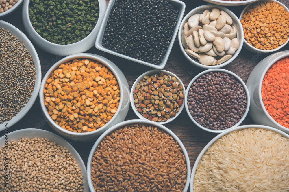 Uncooked pulses,grains and seeds in White bowls over wooden background. selective focus Uncooked pulses,grains and seeds in White bowls over wooden background. selective focus