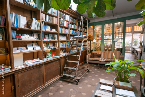 Bookstore with antique bookshelves, decoration, couch and table for coffee and lunch of readers photo