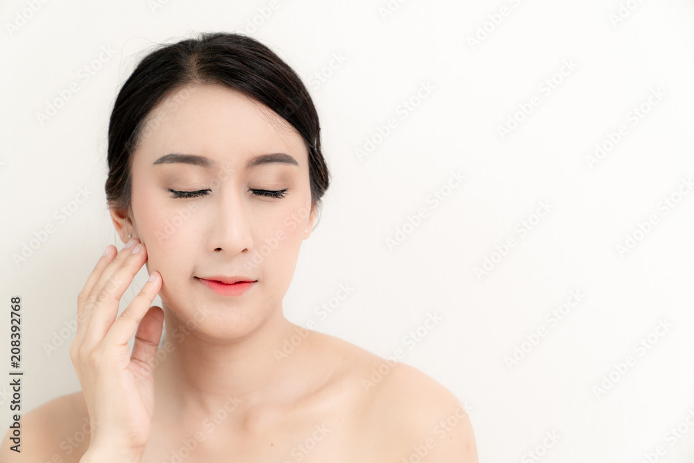 Asian beauty young woman close up head on face with white and healthy bright skin in motion use cometics treatment isolated on white background , included copyspace for advertise your product Asian beauty young woman close up head on face with white and healthy bright skin in motion use cometics treatment isolated on white background , included copyspace for advertise your product