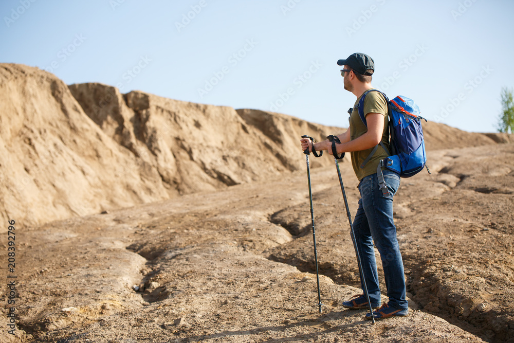 Photo of side athlete with backpack and walking sticks