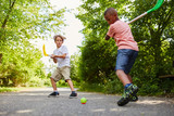 Zwei aktive Kinder spielen Straßenhockey