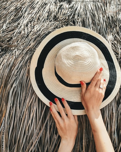 Φωτογραφία Summer hat with hands. Manicure red nails flat lay.