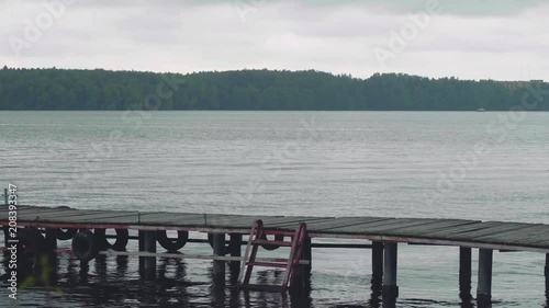 Zoom of woman walking on old wooden pier photo