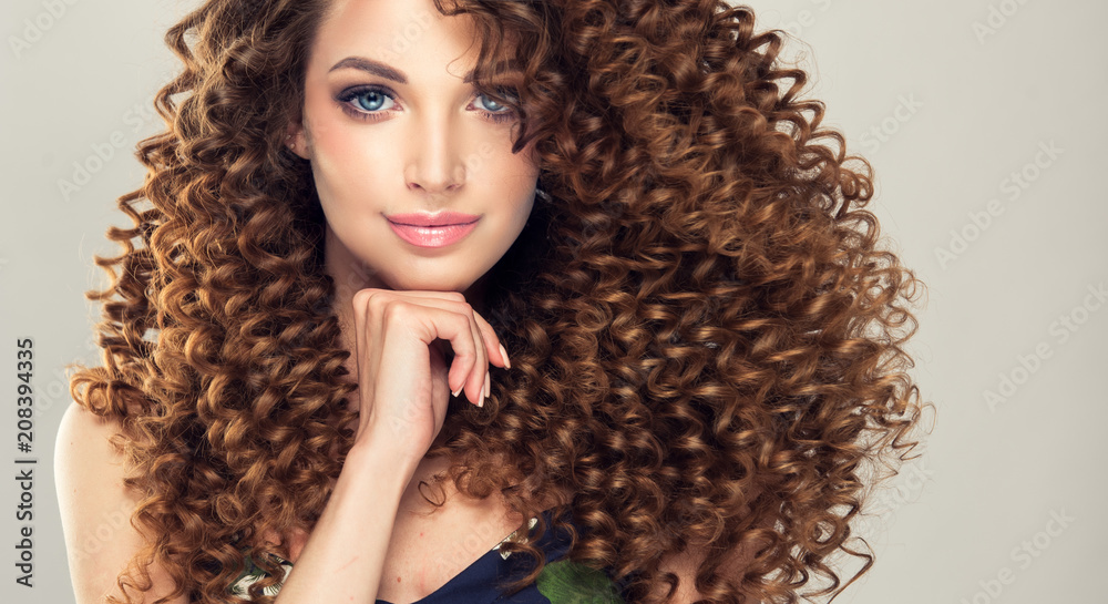Brunette girl with long and shiny curly hair . Beautiful model woman with  wavy hairstyle Stock Photo | Adobe Stock