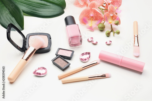 Composition with decorative cosmetics and makeup brushes on white background