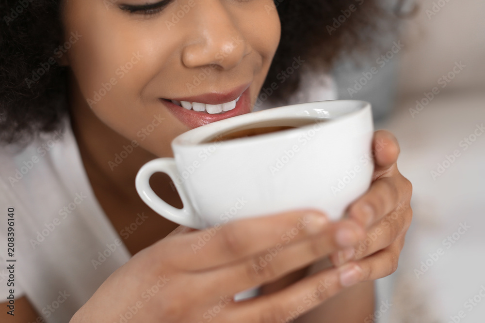 Beautiful African-American woman drinking tea indoors, closeup Beautiful African-American woman drinking tea indoors, closeup