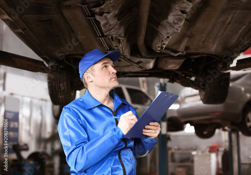 Male mechanic with clipboar...