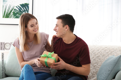 Young woman giving present ...