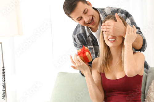 Young man giving present to...