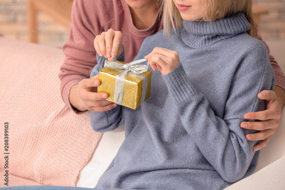Young woman opening gift box from her boyfriend at home, closeup Young woman opening gift box from her boyfriend at home, closeup