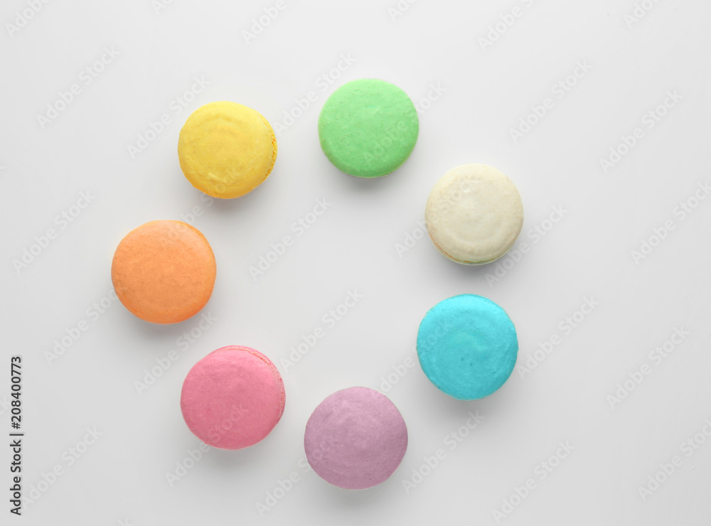 Tasty colorful macarons on white background, flat lay
