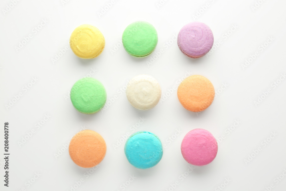 Tasty colorful macarons on white background, flat lay Tasty colorful macarons on white background, flat lay