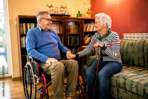 Smiling senior couple sitting and talking at home photo