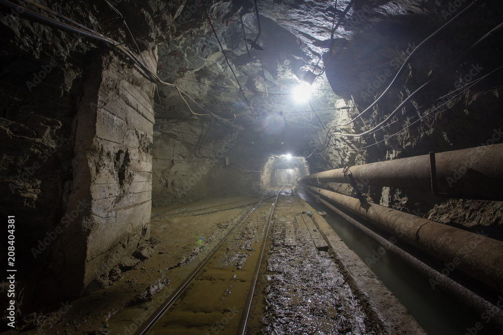 Naklejka premium Underground glod ore mine shaft tunnel gallery with railway rails