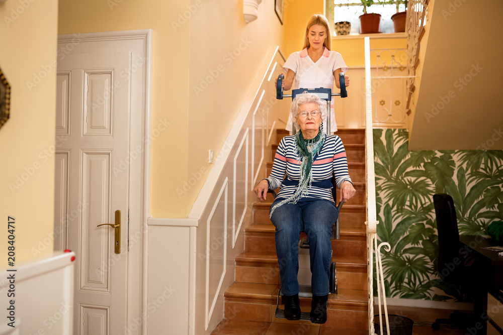 Nurse helps senior woman to climb to the stairs Nurse helps senior woman to climb to the stairs