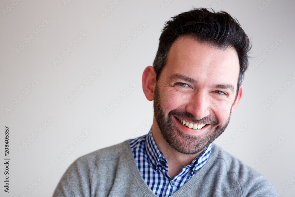 Businessman smiling against white wall