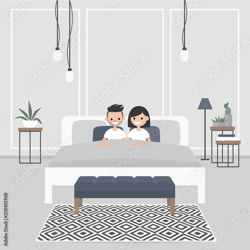 Modern bedroom interior. Couple of young caucasian adults lying in the double bed. Scandinavian design.