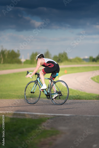 Cyclist man riding road sport bike in sunny day on a mountain road