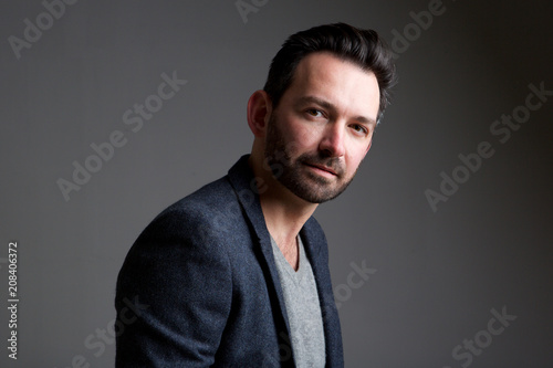 older male fashion model posing against gray background