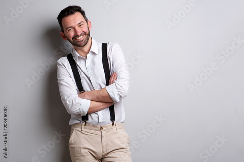 happy man with beard posing against gray wall