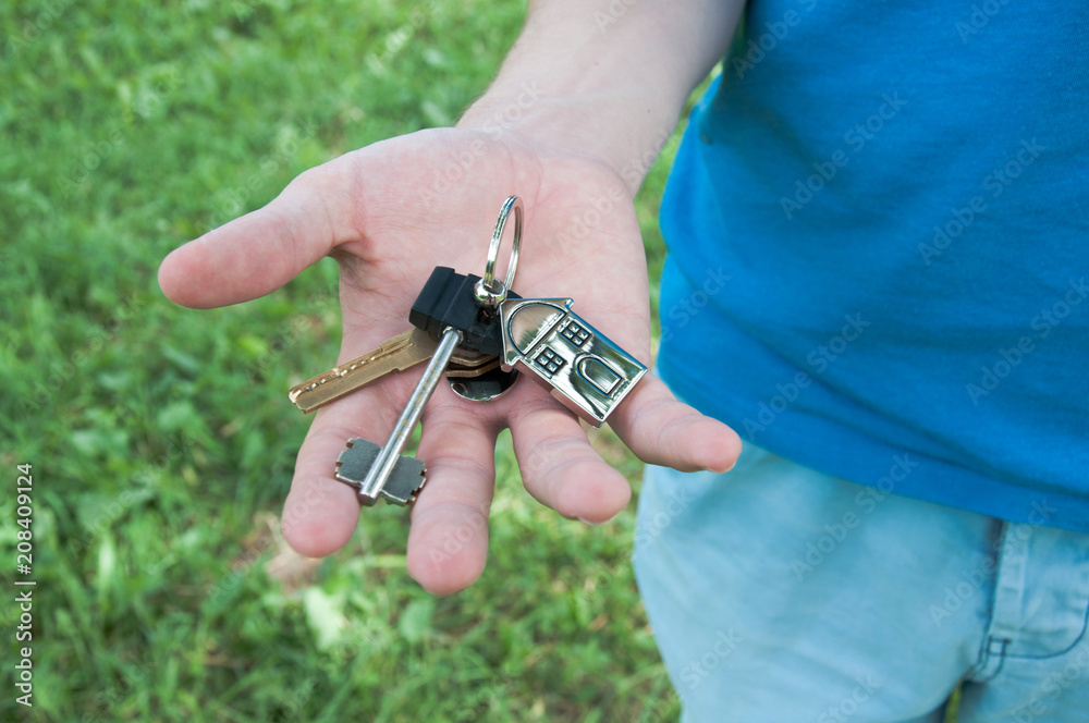 Keys from house closeup in hand. Concept of selling house