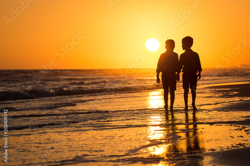 silhouette of boys by the ocean