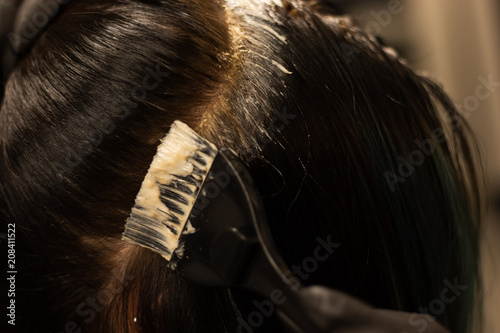 Hair color being applied during a color retouch