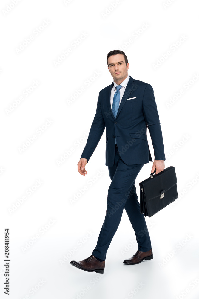 full length view of businessman with briefcase walking and looking at camera on white full length view of businessman with briefcase walking and looking at camera on white