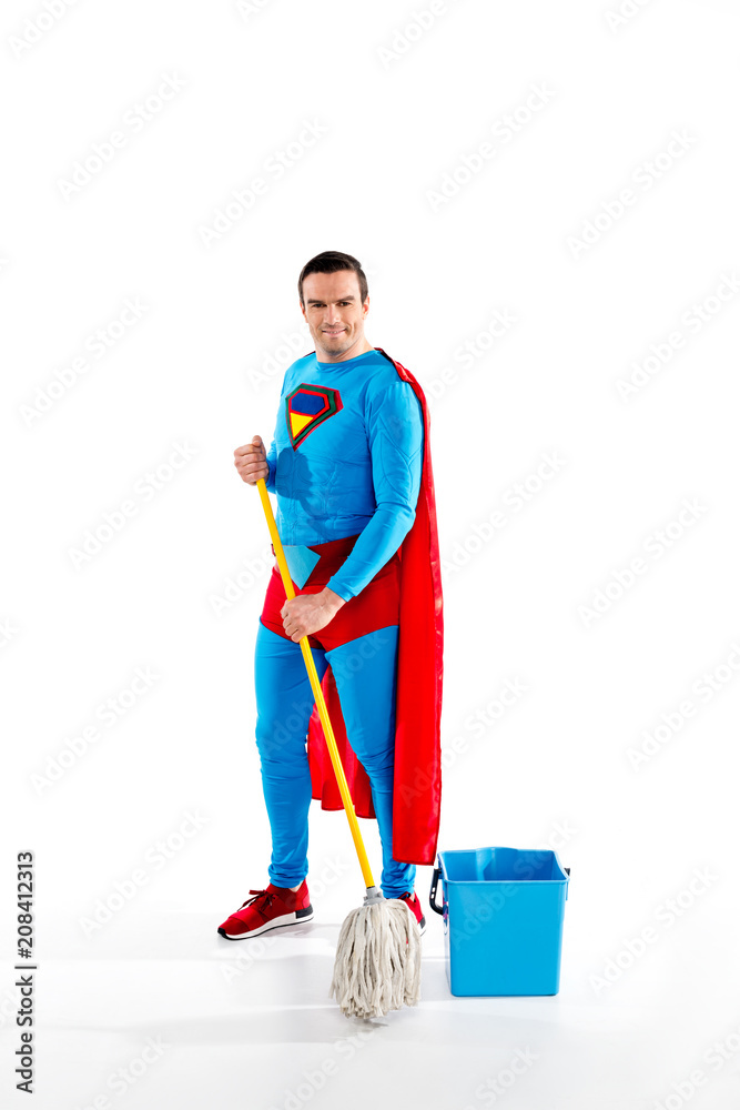 handsome superman holdingholding mop and smiling at camera on white handsome superman holdingholding mop and smiling at camera on white