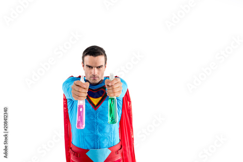 superman holding plastic spray bottles with cleaning liquid and looking at camera isolated on white photo