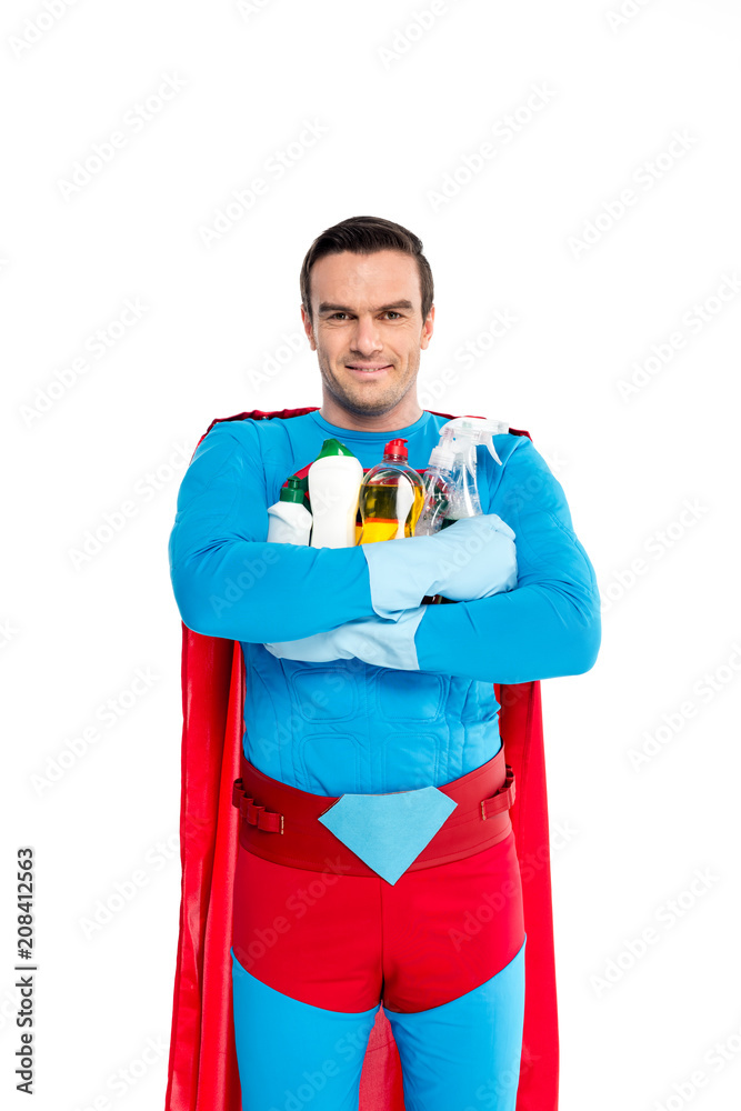 superman in rubber gloves holding cleaning items and smiling at camera isolated on white superman in rubber gloves holding cleaning items and smiling at camera isolated on white