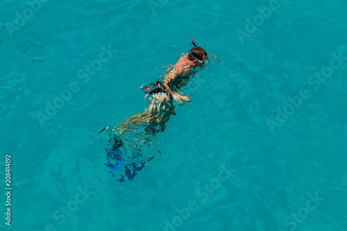 Man swimming with snorkel and paddles