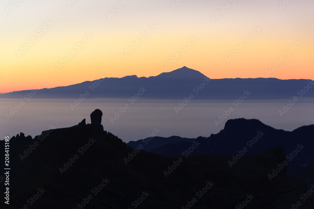 Silhouettes of the mountains of the islands of Gran Canaria and Tenerife. Both islands separated by a sea of ​​clouds. and a sunset.