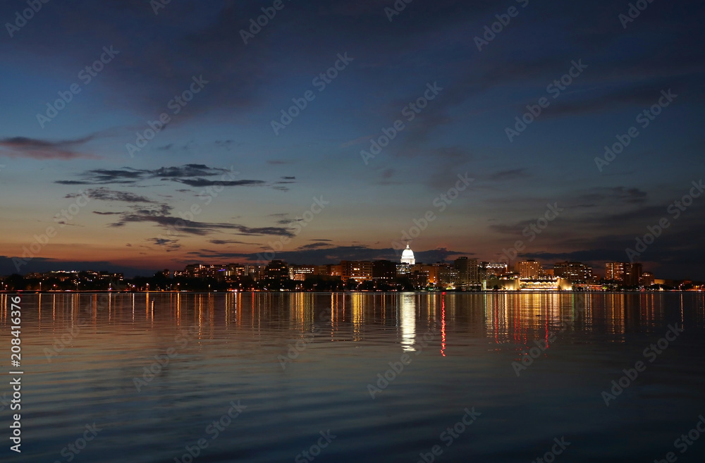 Downtown skyline of Madison, the capital city of Wisconsin, USA. After sunset view with State Capitol building dome against colorful sky reflected in lake Monona.