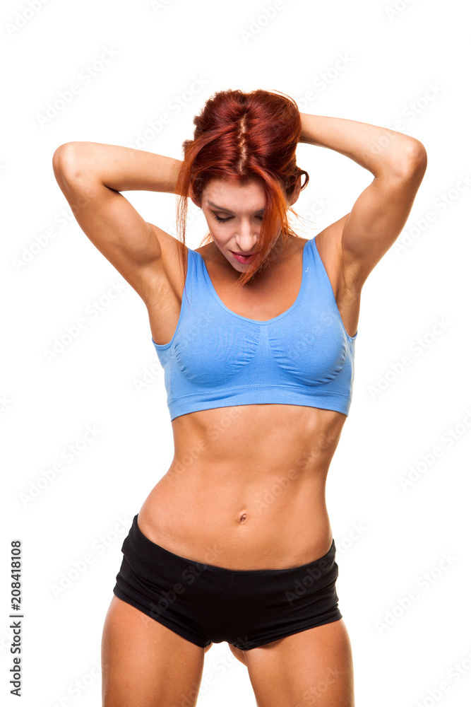 Muscular young woman athlete standing on white background. Woman bodybuilder relaxing after exercise. Muscular young woman athlete standing on white background. Woman bodybuilder relaxing after exercise.