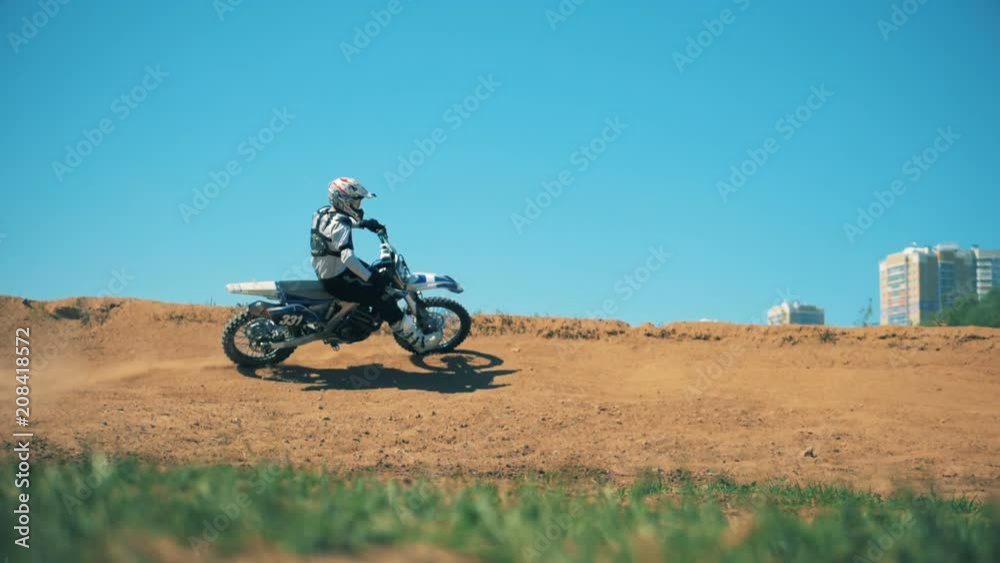 Professional motorcycler is driving across sandy terrain Professional motorcycler is driving across sandy terrain