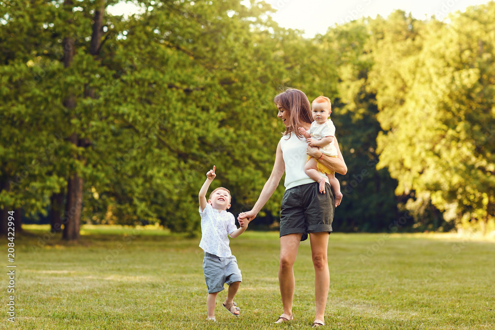 Mother with children in summer park. Mothers Day.