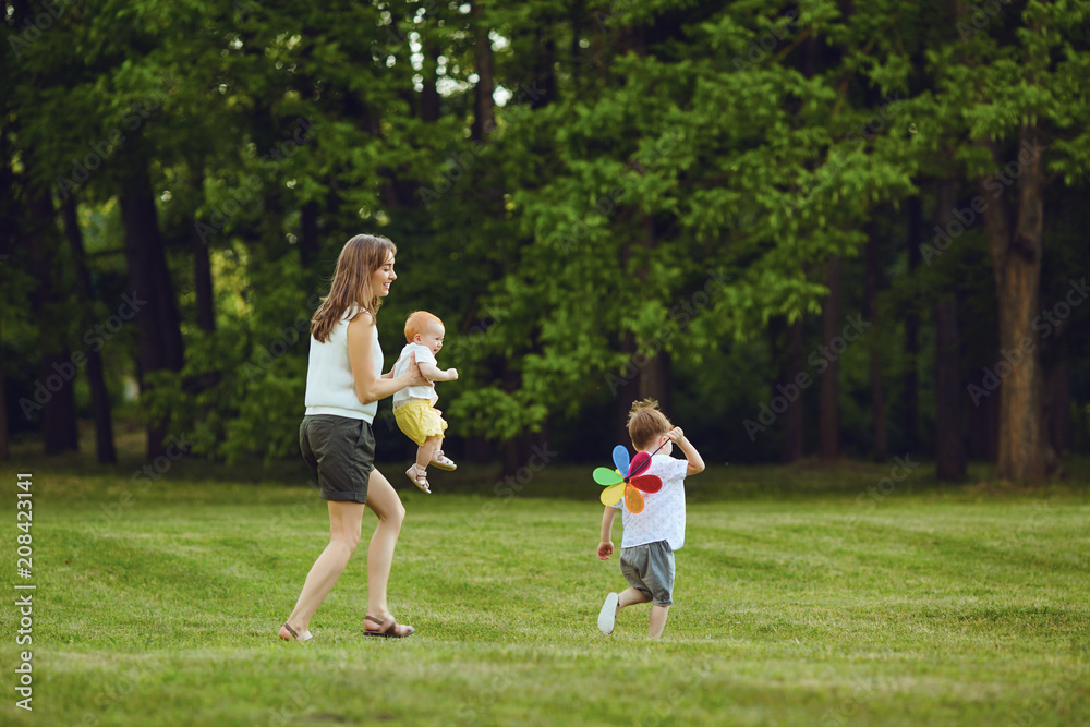 Mother with children in summer park. Mothers Day. Mother with children in summer park. Mothers Day.