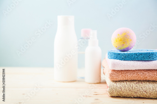 bathroom accessories - towels, cream, bath foam and shampoos on a light, bright background Concept of caring for yourself, your body Place for copy space.