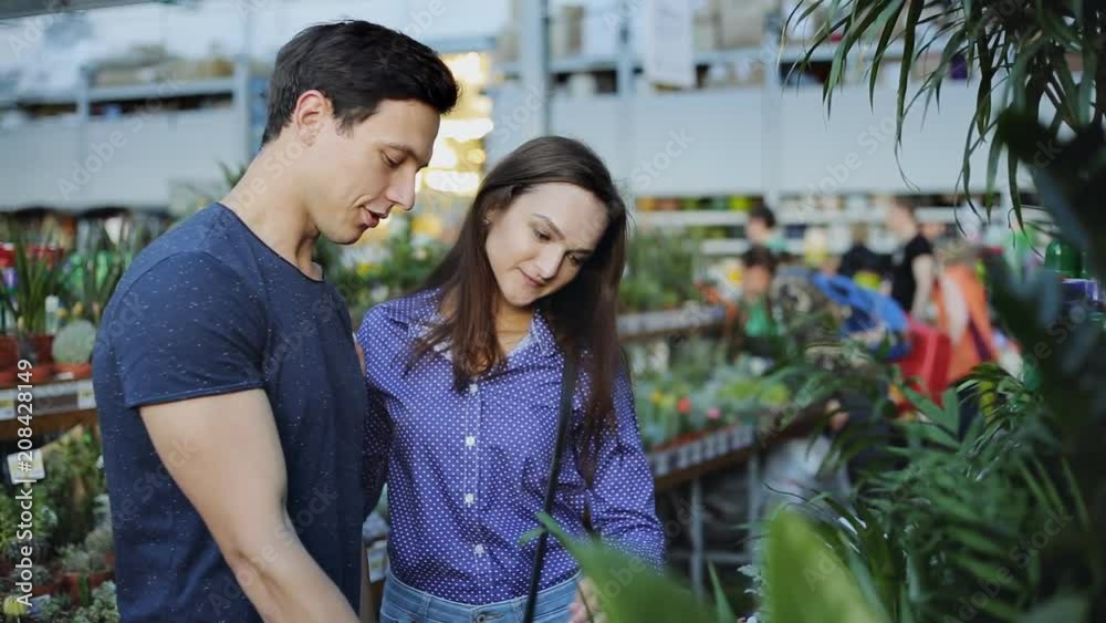 Young couple buying flowers at a garden shop Young couple buying flowers at a garden shop