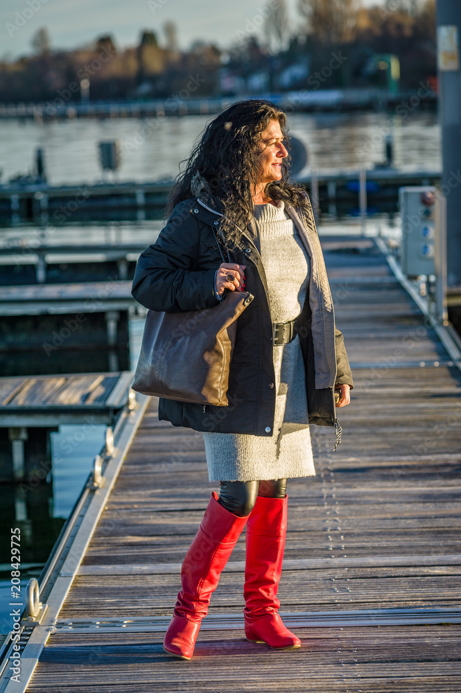 Woman in red overknee boots on a mooring at lake constance.