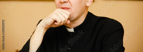 Obraz na plátně Priest in black cassock with clerical collar prays