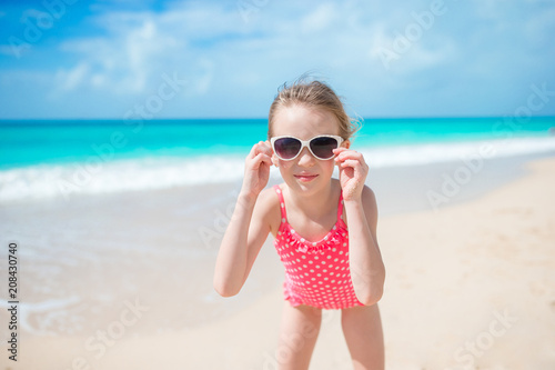 Beautiful little girl in dress at beach having fun. © travnikovstudio
