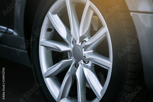 Close-up of aluminium rim of luxury car wheel. Detail background