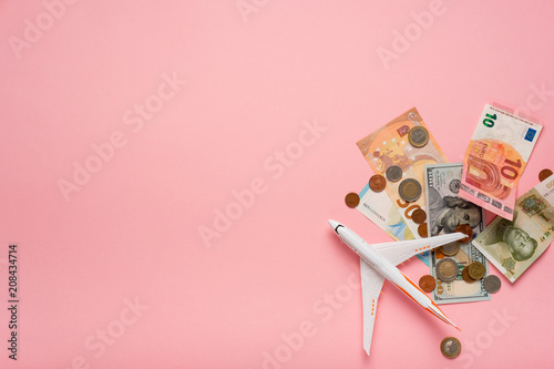 Plane and money on a pink background.  Travel concept.