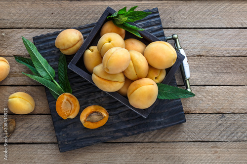 Delicious ripe apricots in a wooden box on the table. copyspace
