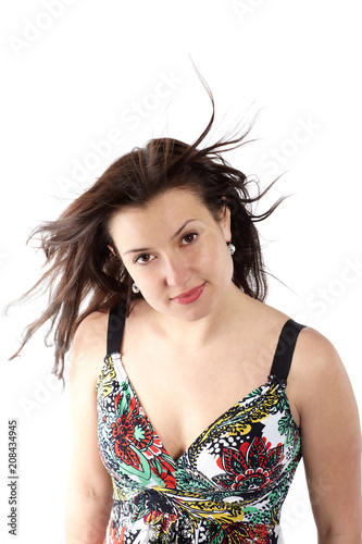 portrait of beautiful woman with fluttering hair in sundress with colorful flower pattern