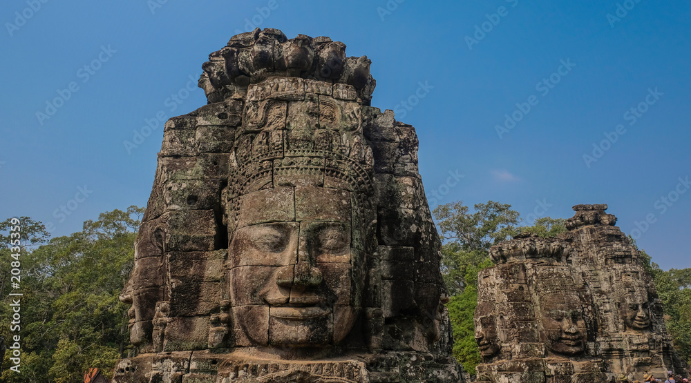 Angkor Temples, Siem Riep, Cambodia - February 12, 2018: Huge face sculpted in stone, exterior of the temple