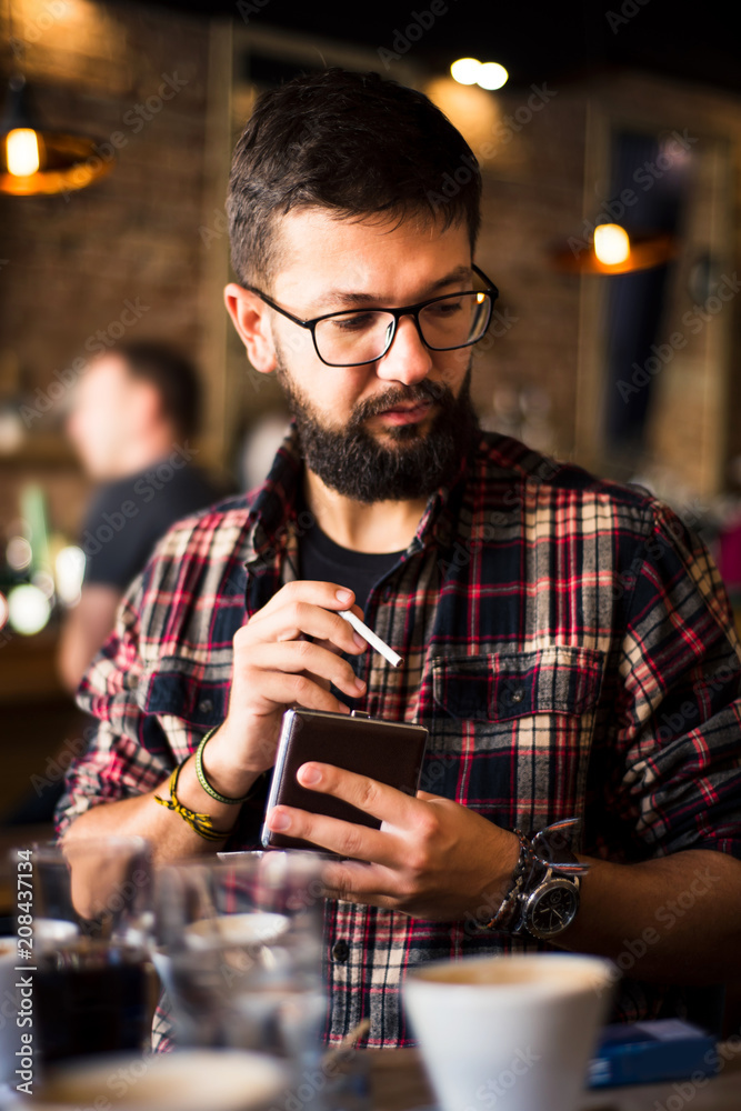 Bearded man in a coffee bar with a cigar
